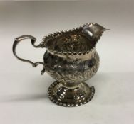 An 18th Century silver cream jug with chased decor