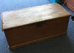A pine hinged top trunk. Est. £30 - £50.