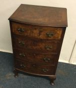 A walnut bow front chest of four drawers. Est. £30