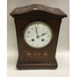 A mahogany inlaid mantle clock. Est. £20 - £30.