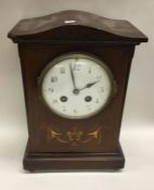 A mahogany inlaid mantle clock. Est. £20 - £30.