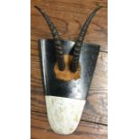 A pair of small antelope horns mounted upon the ti