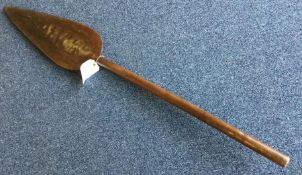 An unusual carved wooden paddle. Est. £30 - £50.