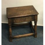 An oak stool on stretcher base. Est. £20 - £30.