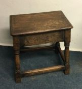 An oak stool on stretcher base. Est. £20 - £30.