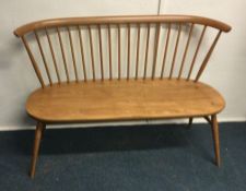 ERCOL: A small two seater stick back bench. Est. £