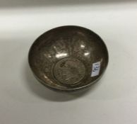 A silver tumbler with early coin to centre. Approx