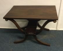 A mahogany occasional table on flowing supports. E