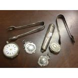 A small silver fob watch together with tongs etc.