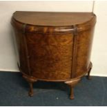 A burr walnut cocktail cabinet. Est. £40 - £60.