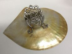 A large silver letter holder with shell decoration