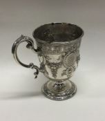 A Victorian silver mug with embossed decoration ch