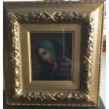 A gilt framed miniature oil on board depicting a lady in blue hooded gown. Approx. 9.5cms x 10.5cm