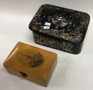 A papier-mâché snuff box together with one other.