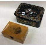 A papier-mâché snuff box together with one other.