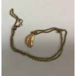 A small gold pendant on fine link chain. Approx. 9