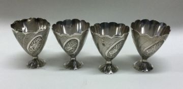 A set of four Continental silver egg cups decorate
