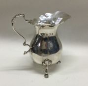 An Edwardian silver cream jug with shaped rim. Lon