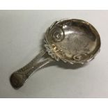 A silver caddy spoon with scroll and engraved deco