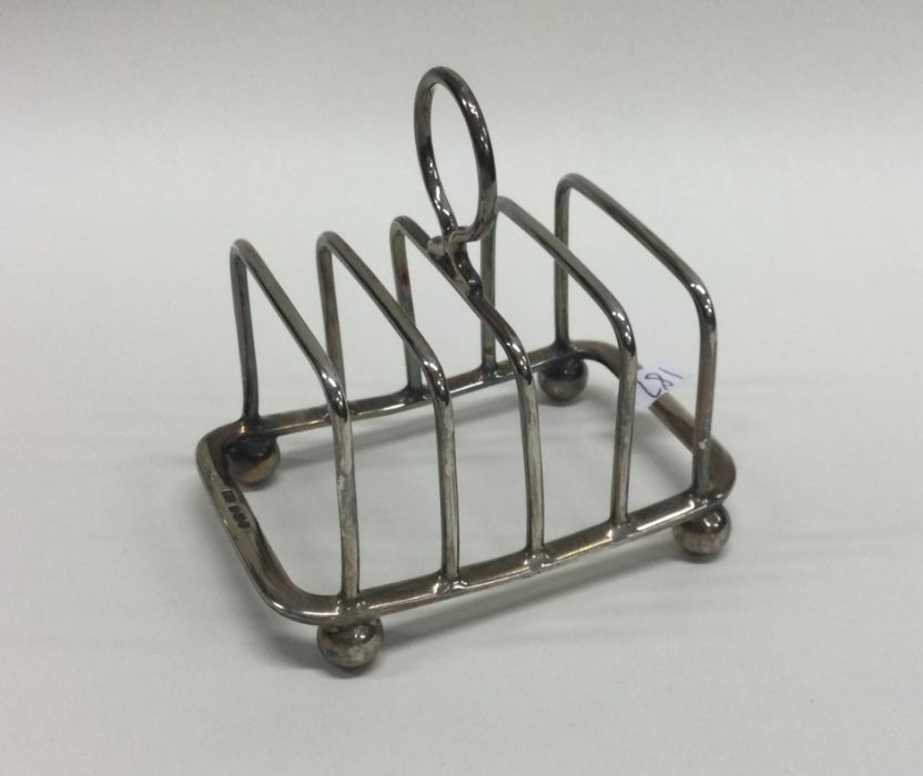 A silver five bar toast rack with ball decoration.