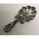 A silver caddy spoon with vine tendril and leaf ha