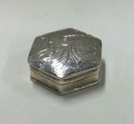 A small silver pill box with engraved decoration.