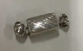 An unusual silver pill box in the form of a sweet.