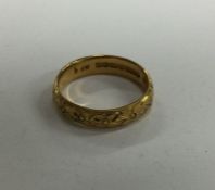 A chased 22 carat gold wedding band. Approx. 4.3 g