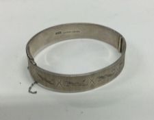 A silver bangle with engraved decoration. Birmingh