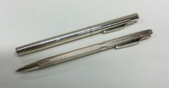 An engine turned silver pen together with one othe