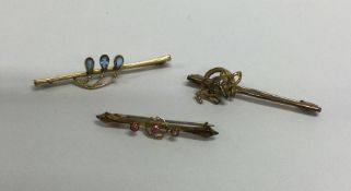 A small gold brooch together with two other gilt b