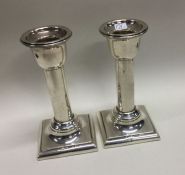 A pair of silver candlesticks with circular column