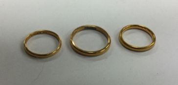 A group of three 22 carat gold wedding bands. Appr