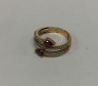 An unusual ruby and diamond crossover ring in 18 c