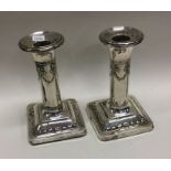 A pair of silver candlesticks decorated with swags