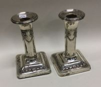 A pair of silver candlesticks decorated with swags