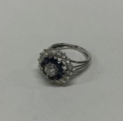 A good large sapphire and diamond circular cluster