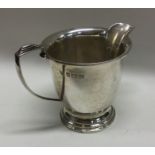 A stylish silver cream jug on spreading foot. Birm