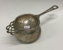 A silver tea strainer on stand. Birmingham 1931. B