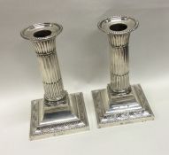 A pair of silver candlesticks with fluted stems. L
