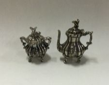 A heavy miniature cast silver teapot together with