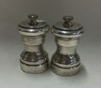 A pair of modern silver pepper grinders. Marked St