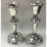 A oair of circular silver candlesticks of typical