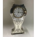 A large engraved silver clock with swag decoration