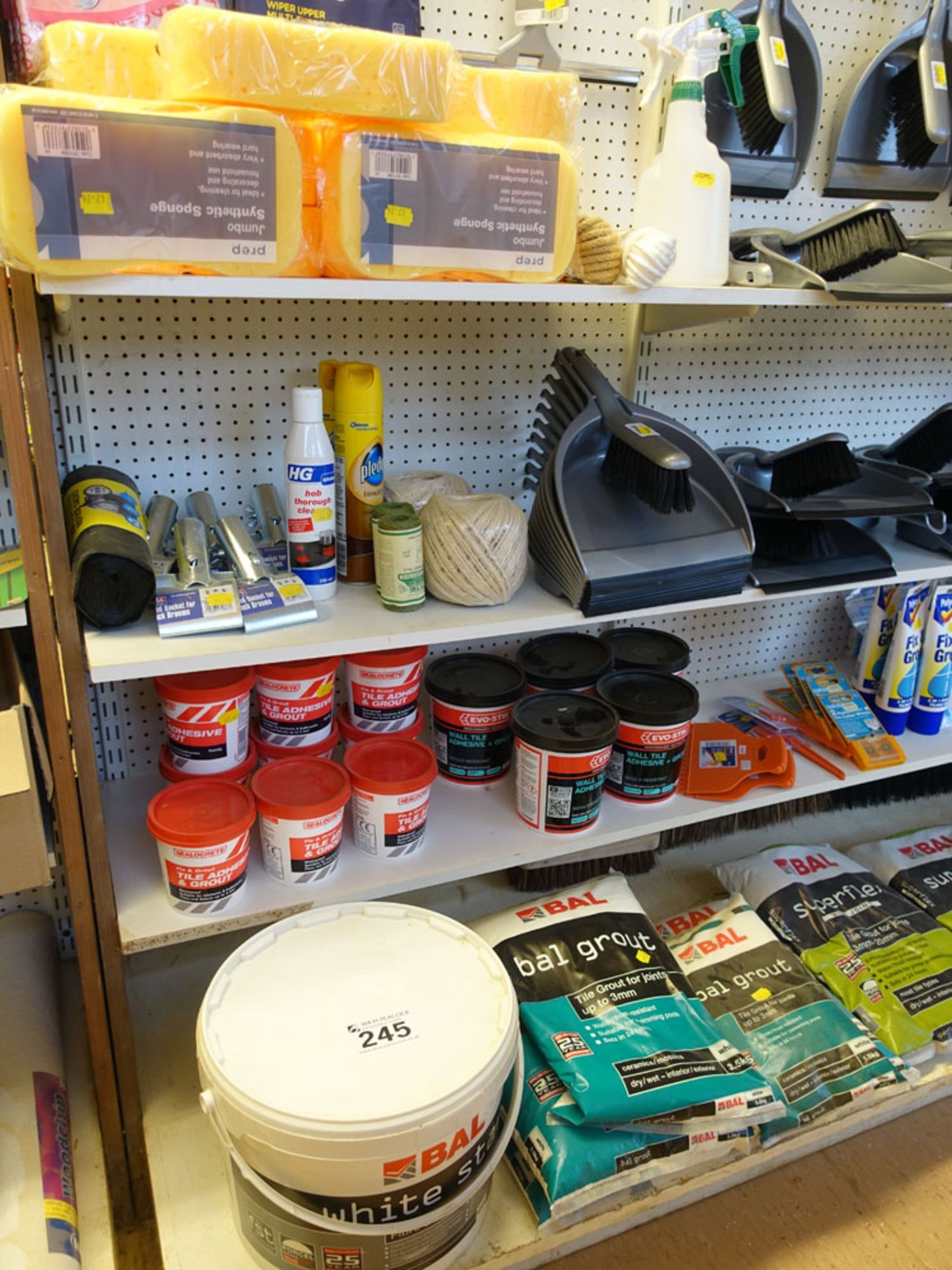 2 shelves containing tile grout and adhesive, etc