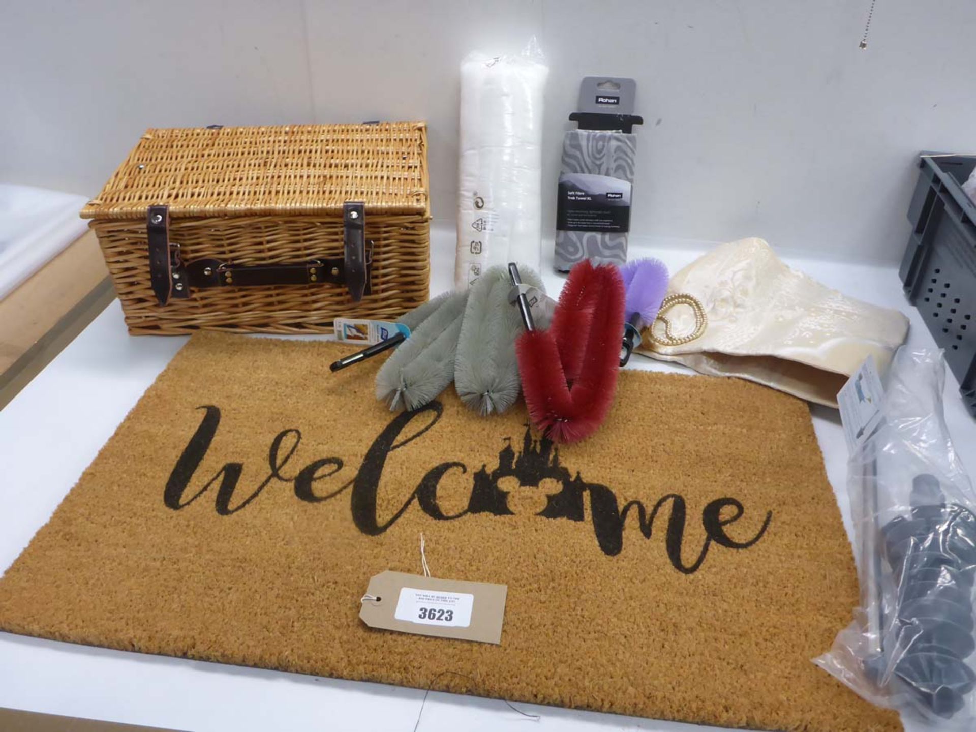 Wicker hamper, Welcome door mat, radiator brushes, toilet plunger, prayer mat, Rohan trek towel ad