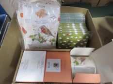Box containing organic cotton single mittens, fine china mugs, A5 notebooks, etc.