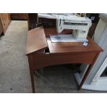 Singer sewing machine work station with fold out table storage