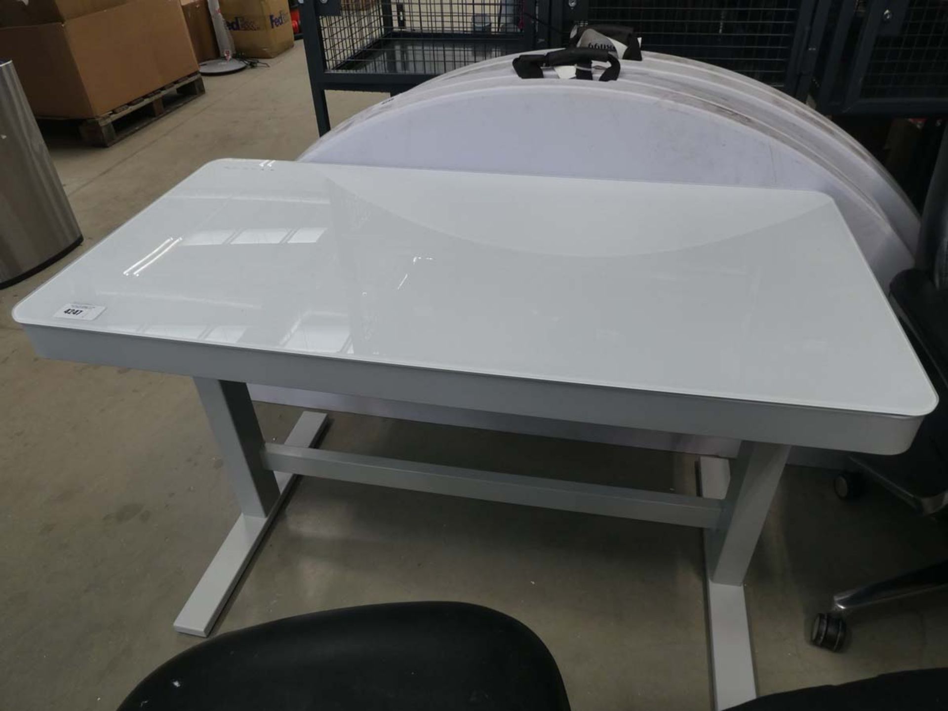 White glass topped rise and fall office desk