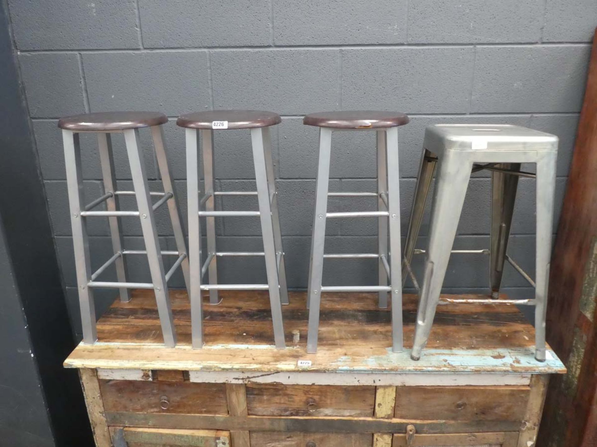3 wooden topped bar stools with metal frames and one metal stool